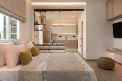 a bedroom with a large bed and a living room at HELENA’S RETREAT in Rhodes Town