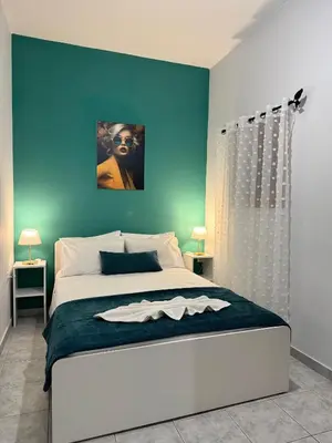 a bedroom with a large bed with a blue wall at Aesthetic Cozy Haven in Kremasti