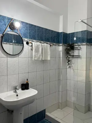 a bathroom with a sink and a shower with a mirror at Aesthetic Cozy Haven in Kremasti