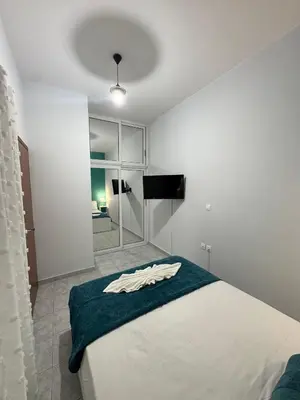 a bedroom with a white bed with a blue blanket at Aesthetic Cozy Haven in Kremasti