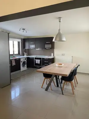 a kitchen with a wooden table and some chairs at Calm Haven 2024 in Ialyssos