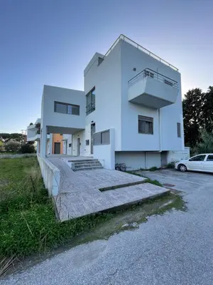 a white house with a car parked in front of it at Calm Haven 2024 in Ialyssos