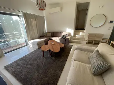 a living room with a couch and a table at Calm Haven 2024 in Ialyssos