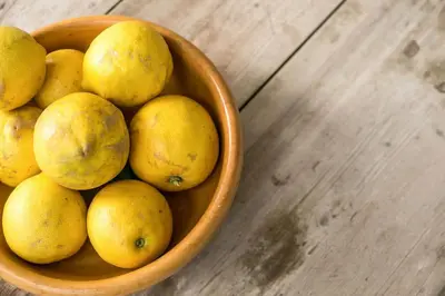 a bowl of yellow fruit on a wooden table at Villa Kaya in Haraki