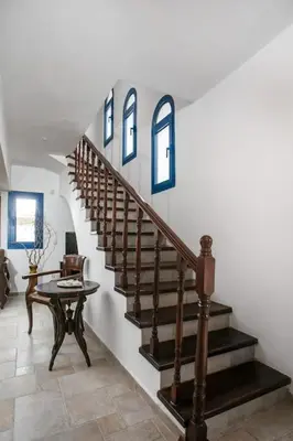 a staircase in a living room with a table at Villa Kaya in Haraki