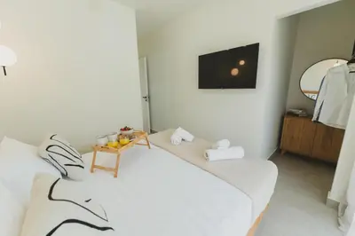 a white room with two beds and a table at Aiolia Villa in Lachania