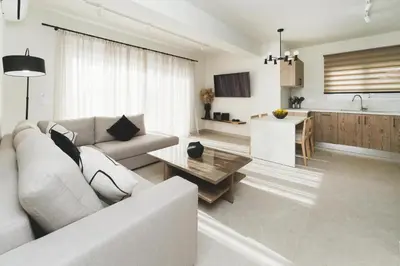 a living room with a couch and a table and a kitchen at Aiolia Villa in Lachania