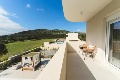 a balcony with chairs and a view of a mountain at Cleopatras Villa in Lachania
