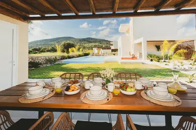 a table with food on it with a view of a house at Cleopatras Villa in Lachania