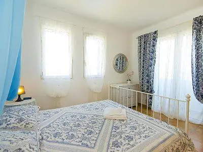 a bedroom with a large bed and windows at White Houses Villas in Gennadi