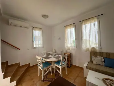 a dining room with a table and chairs and a couch at White Houses Villas in Gennadi
