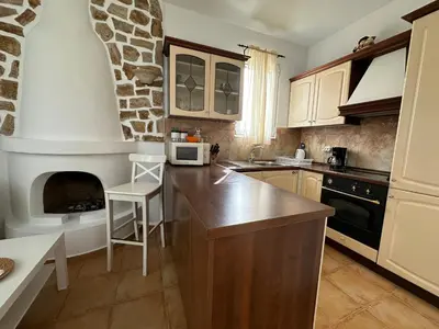 a kitchen with a counter and a fireplace in it at White Houses Villas in Gennadi