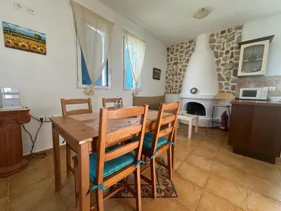 a kitchen and dining room with a wooden table and chairs at White Houses Villas in Gennadi