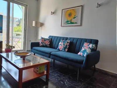 a living room with a blue couch and a coffee table at Mary's House in Rhodes Town