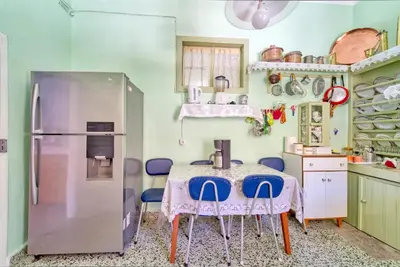 a kitchen with a table and a refrigerator at Waterfront House Pedi in Symi