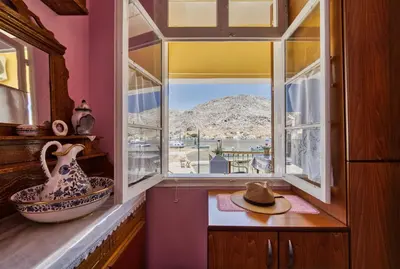 a window with a view of a mountain at Waterfront House Pedi in Symi
