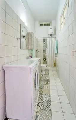 a white bathroom with a sink and a toilet at Waterfront House Pedi in Symi