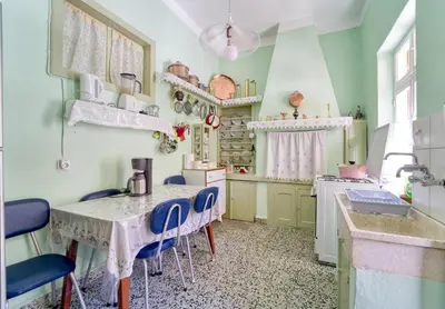 a kitchen with a table and blue chairs in it at Waterfront House Pedi in Symi