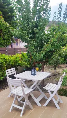 a white picnic table and two chairs next to a tree at Villa Marina, apartment Hara, Rodos in Ixia