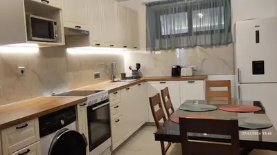 a kitchen with white cabinets and a table with a dining room at Villa Marina, apartment Hara, Rodos in Ixia