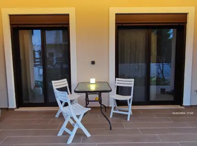 a table and chairs with a candle on a patio at Villa Marina, apartment Hara, Rodos in Ixia