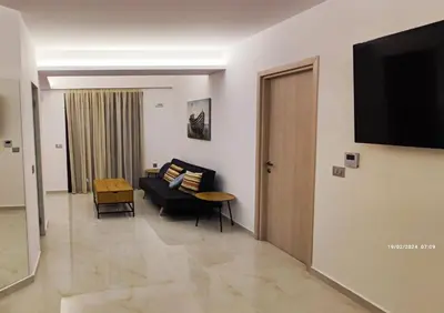 a living room with a couch and a television on a wall at Villa Marina, apartment Hara, Rodos in Ixia