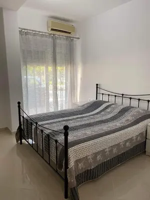 a bed in a white bedroom with a window at Rhodes Volkshaus in Afantou