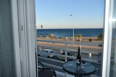 a table with a bottle of wine and a view of the ocean at Alios apartment in Rhodes Town
