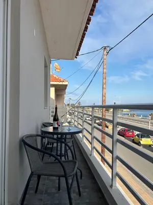 a balcony with a table and chairs and a view of the beach at Alios apartment in Rhodes Town