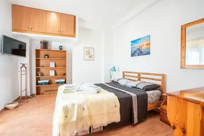 a bedroom with a bed with a table and a tv at Ciel Rhodes in Rhodes Town