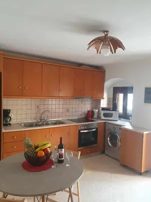 a kitchen with a table with a bowl of fruit on it at Aggeliki's House in Symi