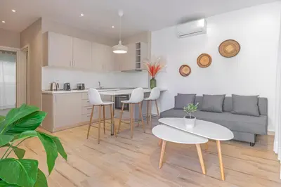 a kitchen and living room with a couch and a table at Sky Char Ialysos in Ialyssos