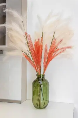 a glass vase with feathers in it on a counter at Sky Char Ialysos in Ialyssos