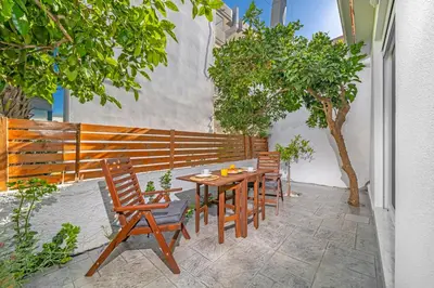a wooden table and chairs on a patio at Sky Char Ialysos in Ialyssos
