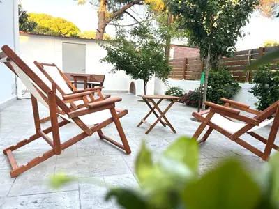 two wooden chairs and a table on a patio at Sky Char Ialysos in Ialyssos