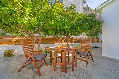 a wooden table and two chairs and trees at Sky Char Ialysos in Ialyssos