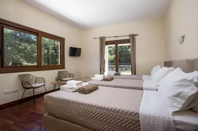 two beds in a room with two windows at Luxury Villa Amaltheia Rhodes in Koskinou