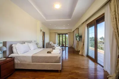 a bedroom with a large bed and a large window at Luxury Villa Amaltheia Rhodes in Koskinou
