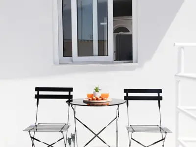 two chairs and a table in front of a window at SunView Studio in Kremasti