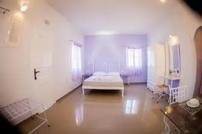 a bedroom with a white bed and purple walls at Marea Studios in Symi