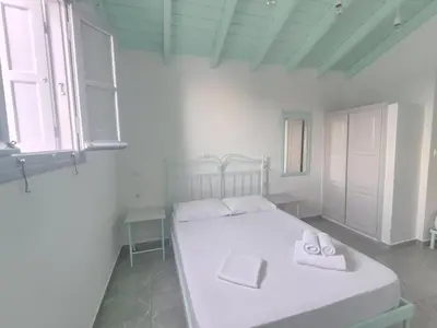 a bedroom with a white bed with towels on it at Marea Studios in Symi