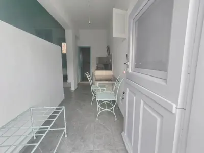 a hallway with two chairs and a table and a window at Marea Studios in Symi
