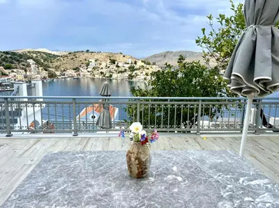 a stuffed animal sitting on a table on a balcony at Marea Studios in Symi