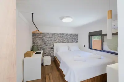 a bedroom with two beds and a brick wall at Casa Napais Earth Retreat in Archangelos