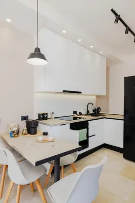 a white kitchen with a table and chairs at Casa Napais Earth Retreat in Archangelos