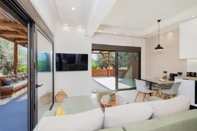 a living room and dining room with sliding glass doors at Casa Napais Earth Retreat in Archangelos