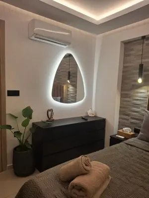 a bedroom with a bed and a mirror at Prifti Luxury apartment in Faliraki
