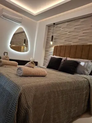 a bedroom with a large bed with a large window at Prifti Luxury apartment in Faliraki