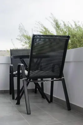 a black chair sitting on top of a balcony at Paradise Apartment, Lardos Village in Lardos