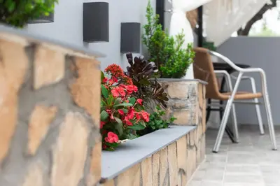 a retaining wall with flowers on a patio at Paradise Apartment, Lardos Village in Lardos